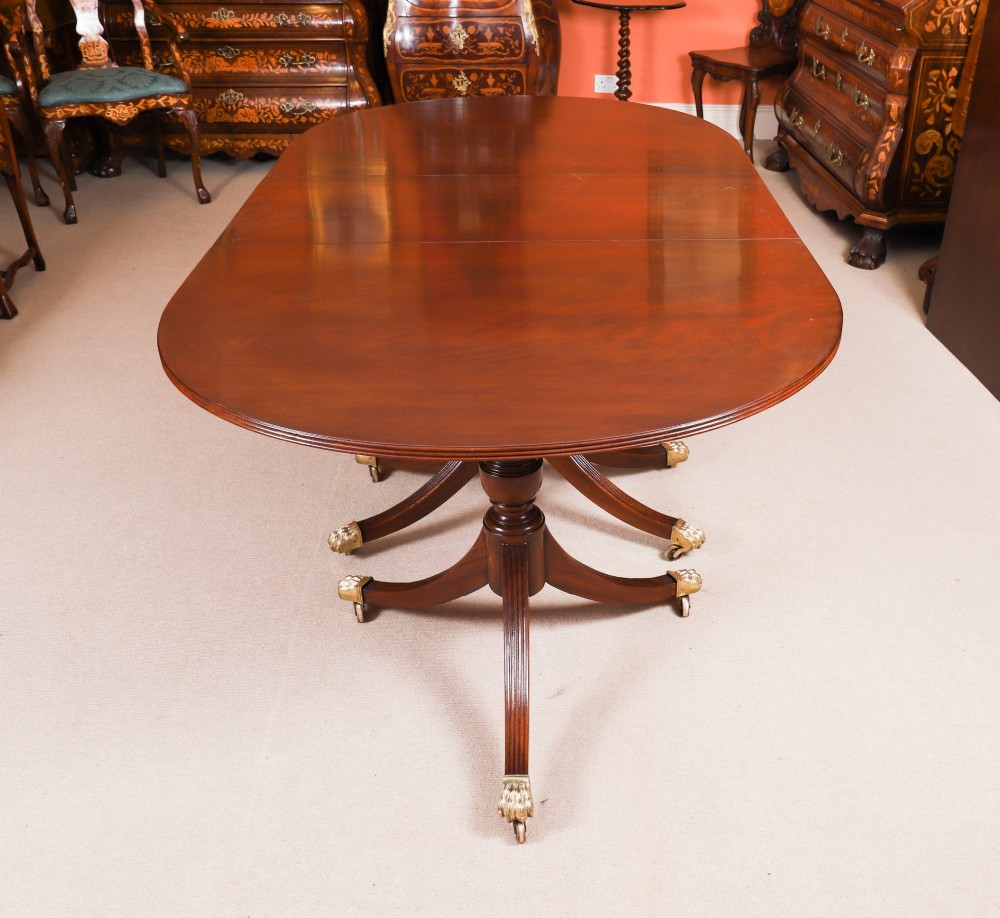 An extended mahogany Regency Revival triple pillar dining table with reeded legs and brass paw castors. View VIII