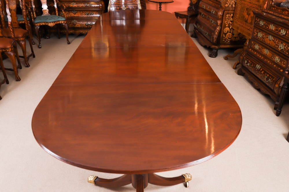 An extended mahogany Regency Revival triple pillar dining table with reeded legs and brass paw castors. View X