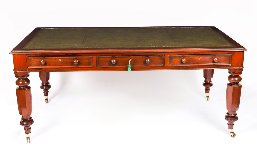 A nineteenth-century mahogany partners writing table featuring a green leather inset surface, six drawers with turned knobs, and octagonal turned legs on brass castors. View II