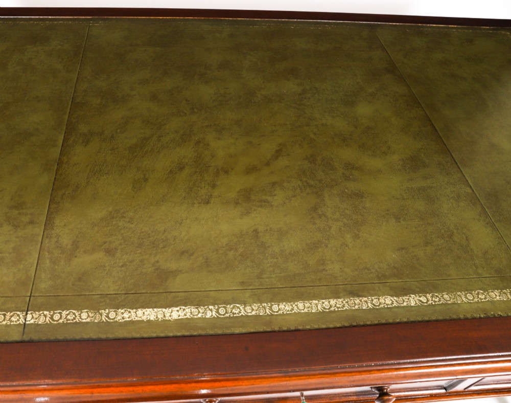 A nineteenth-century mahogany partners writing table featuring a green leather inset surface, six drawers with turned knobs, and octagonal turned legs on brass castors. View VIII