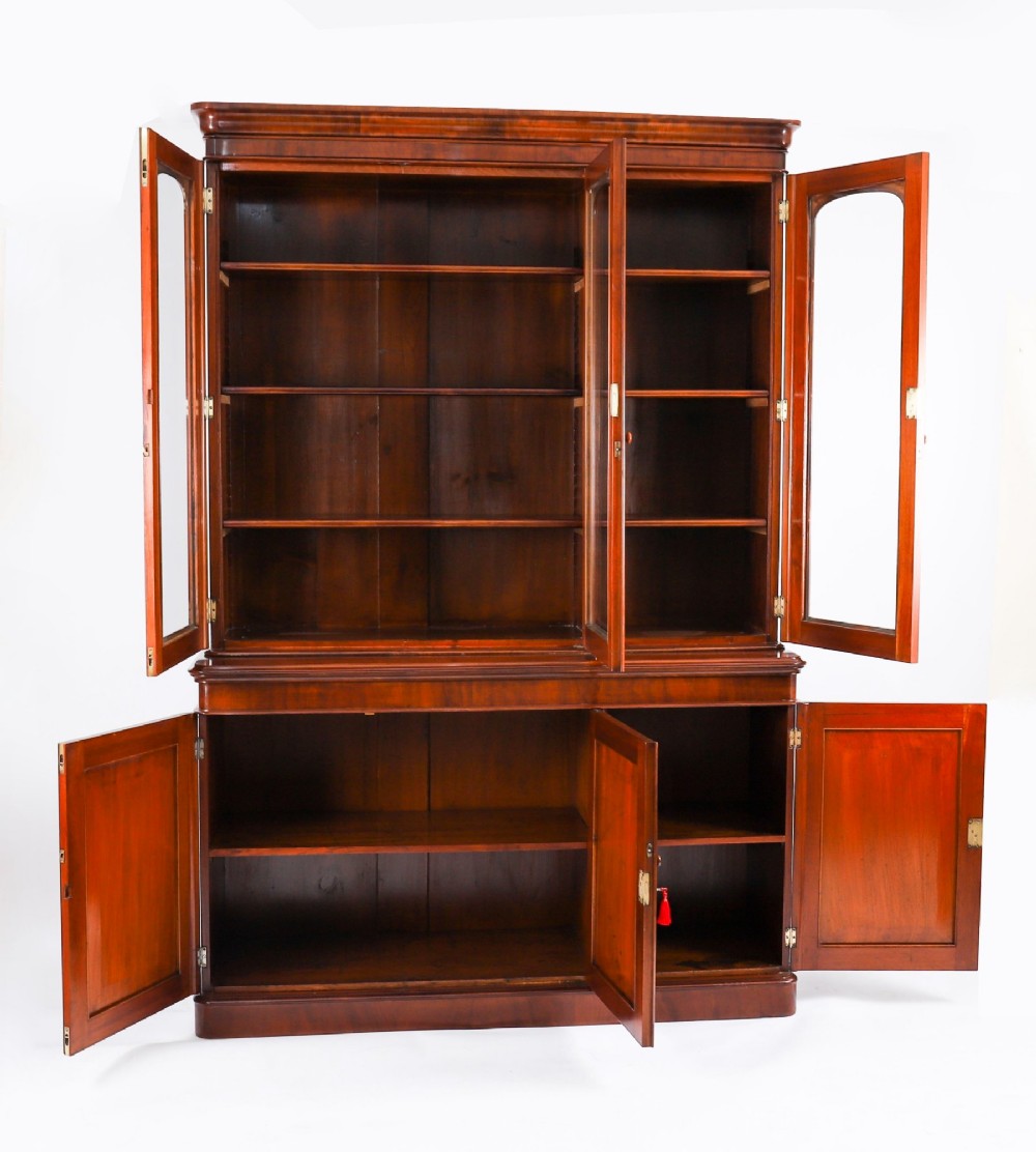 A large 19th-century Victorian flame mahogany library bookcase featuring a glazed three-door upper section filled with books above a solid three-door cupboard base. View XII