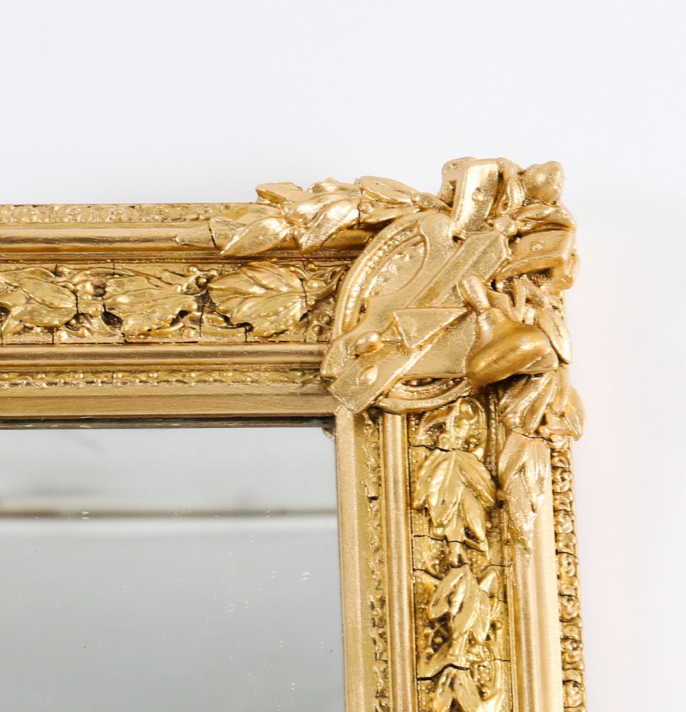 A rectangular nineteenth-century gold giltwood mirror featuring carved Masonic emblems, floral mouldings, and a crest. View VII