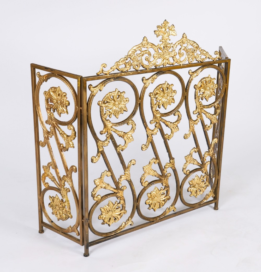 A nineteenth-century French Louis XIV Revival three-panel folding fire screen made from gilt brass featuring intricate floral scrollwork and an ornate cresting motif. View III