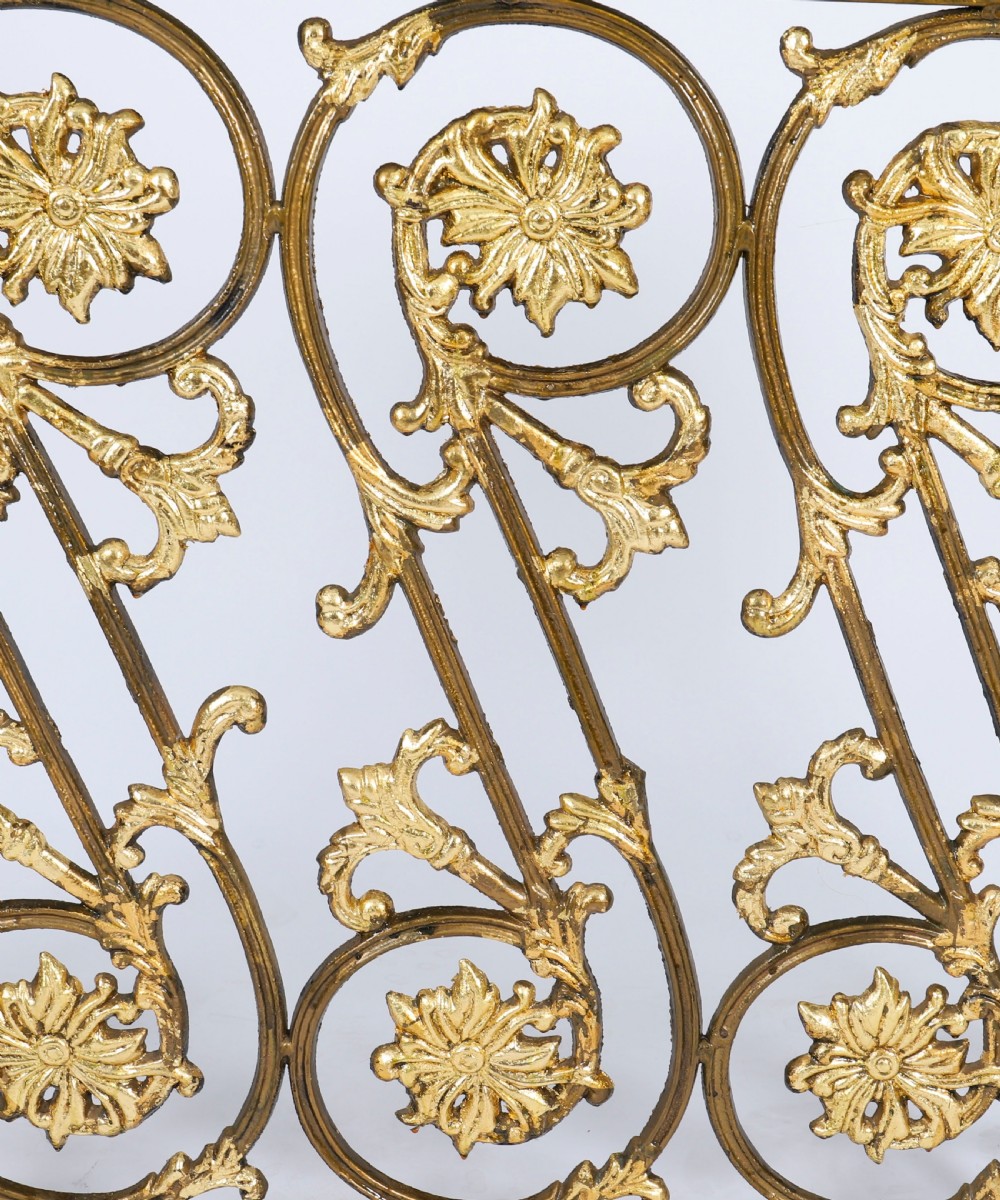 A nineteenth-century French Louis XIV Revival three-panel folding fire screen made from gilt brass featuring intricate floral scrollwork and an ornate cresting motif. View V