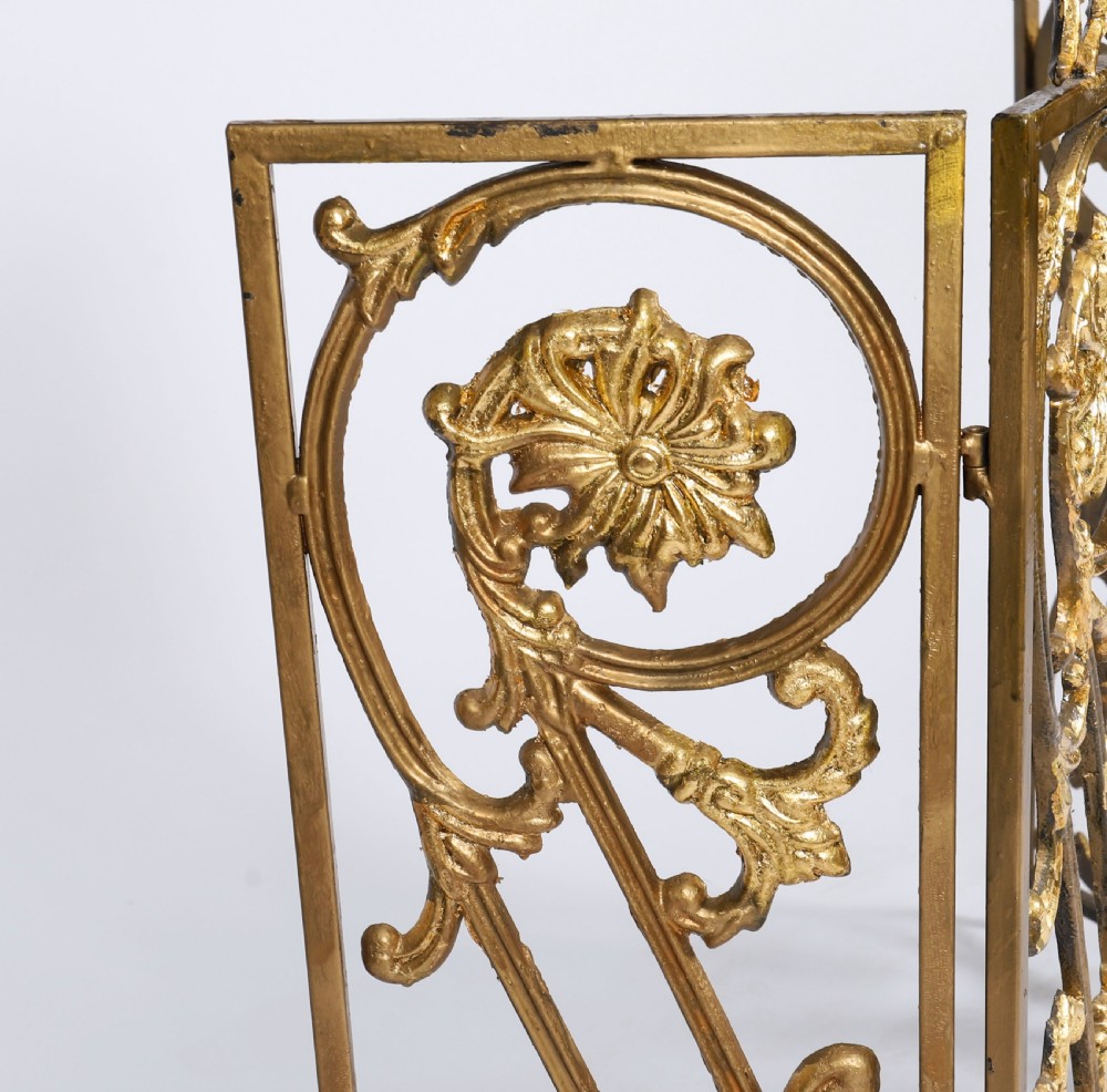 A nineteenth-century French Louis XIV Revival three-panel folding fire screen made from gilt brass featuring intricate floral scrollwork and an ornate cresting motif. View VII