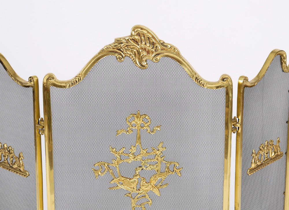 A three-fold French Rococo gilt bronze fire screen featuring fine wire mesh panels, ornate scrollwork cresting, and a central flaming torch motif. View III