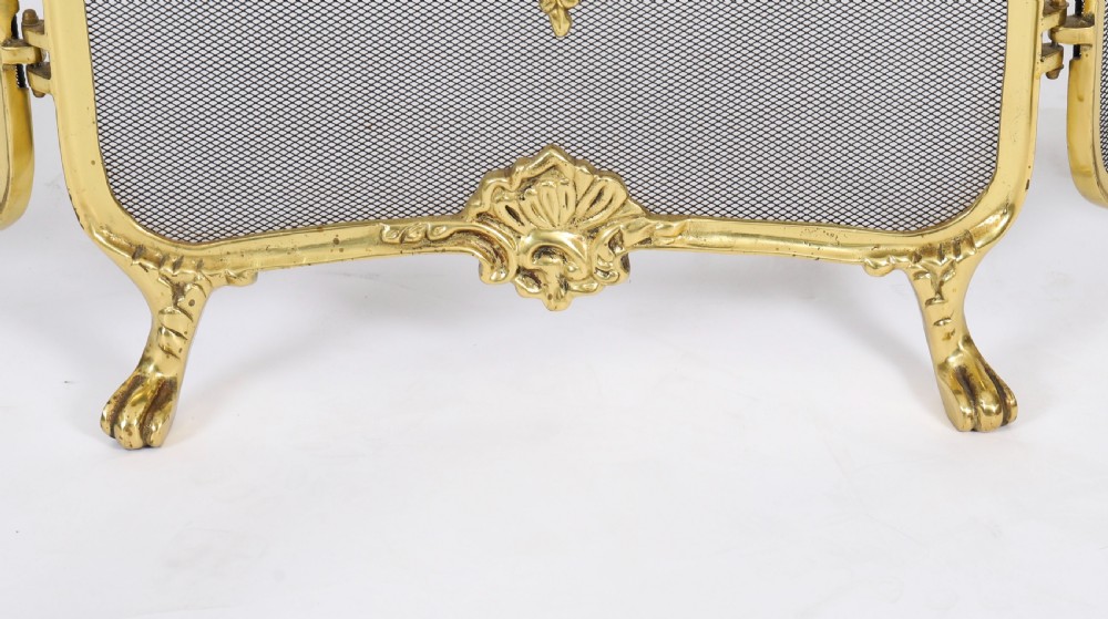 A three-fold French Rococo gilt bronze fire screen featuring fine wire mesh panels, ornate scrollwork cresting, and a central flaming torch motif. View VII