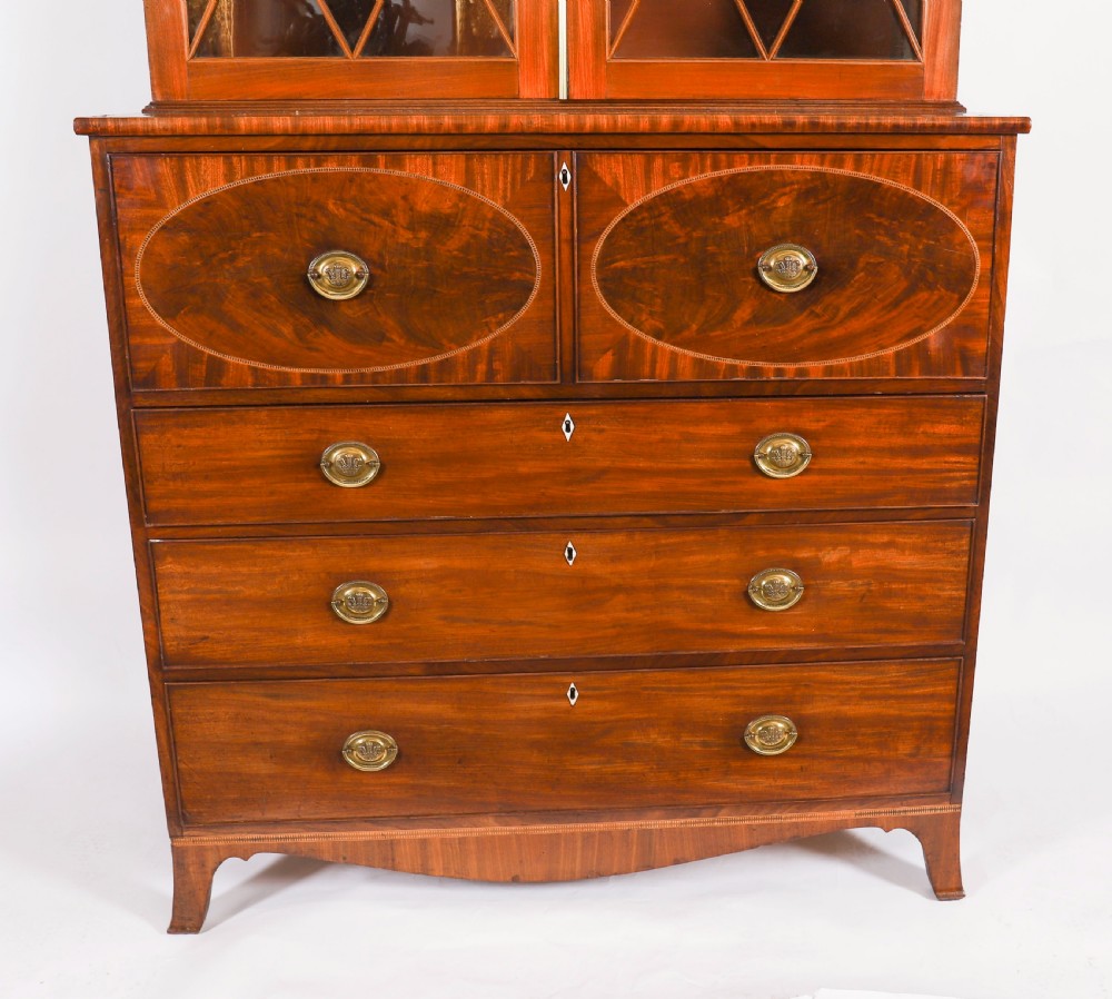 A George III flame mahogany secretaire bookcase featuring an arched pediment, astragal glazed doors, and lower drawers on bracket feet. View VI