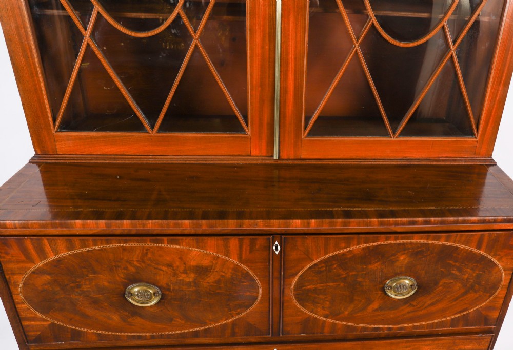 A George III flame mahogany secretaire bookcase featuring an arched pediment, astragal glazed doors, and lower drawers on bracket feet. View VIII