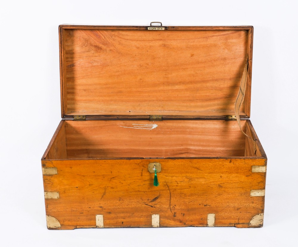 A rectangular 19th-century warm brown camphorwood military campaign trunk featuring flush brass corner brackets, protective metal straps, side drop handles, and a central brass keyhole escutcheon. View III