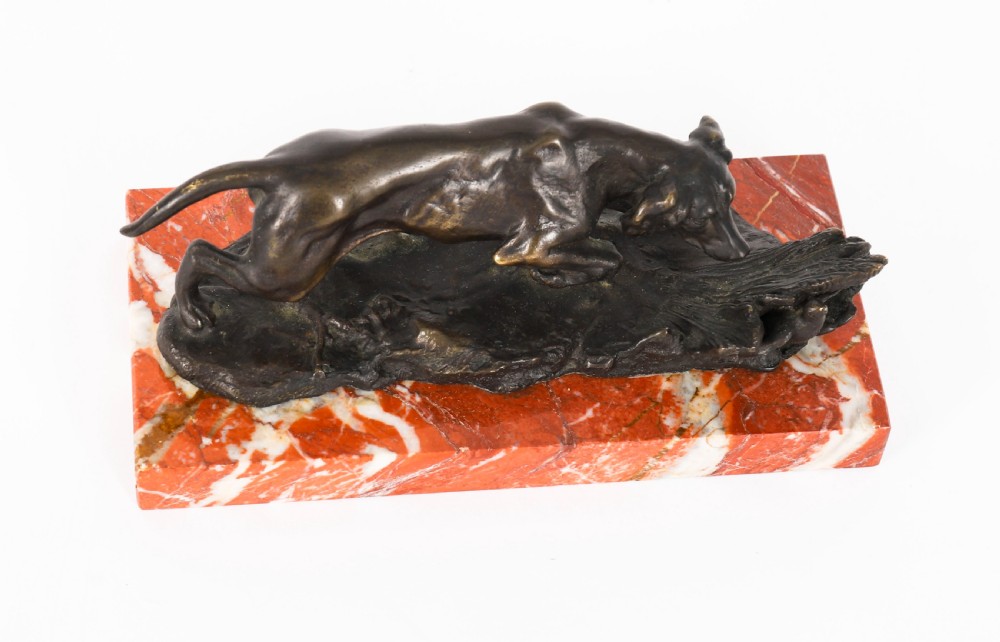 A dark brown patinated bronze sculpture of a hunting dog stalking prey, mounted on a rectangular red and white veined marble base. View VI