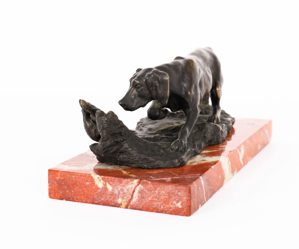 A dark brown patinated bronze sculpture of a hunting dog stalking prey, mounted on a rectangular red and white veined marble base. View VII