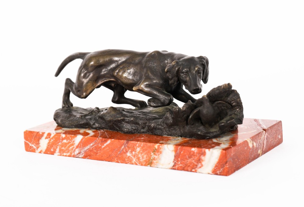 A dark brown patinated bronze sculpture of a hunting dog stalking prey, mounted on a rectangular red and white veined marble base. View VIII