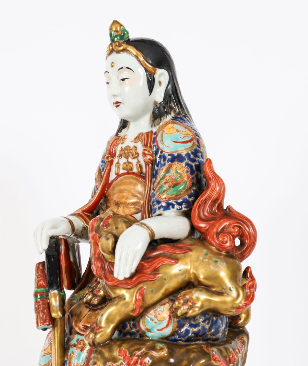 An antique Japanese Kutani porcelain sculpture depicting Guanyin standing beside a shishi lion with detailed polychrome drapery and gold leaf accents. View XII