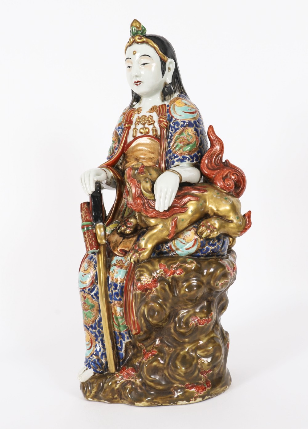 An antique Japanese Kutani porcelain sculpture depicting Guanyin standing beside a shishi lion with detailed polychrome drapery and gold leaf accents. View XVI