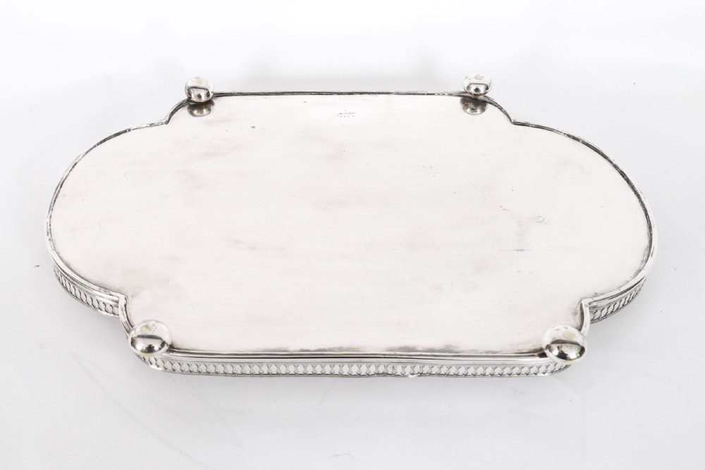 An Edwardian silver-plated gallery tray featuring a pierced rim, engraved foliate scrollwork, twin handles, and ball feet. View XIII