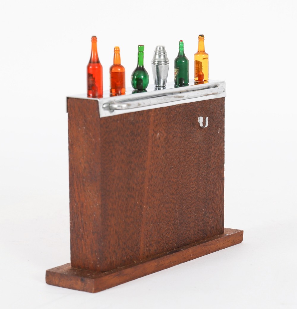 An Art Deco wooden cocktail stick holder featuring miniature liquor bottle handles and a central cocktail shaker pick atop a chrome-trimmed base. View III