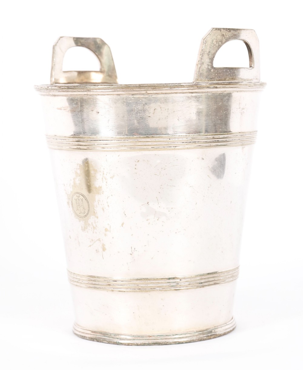 An Art Deco silver-plated champagne cooler featuring angular raised handles, horizontal reeded bands, and an engraved circular crest. View VII