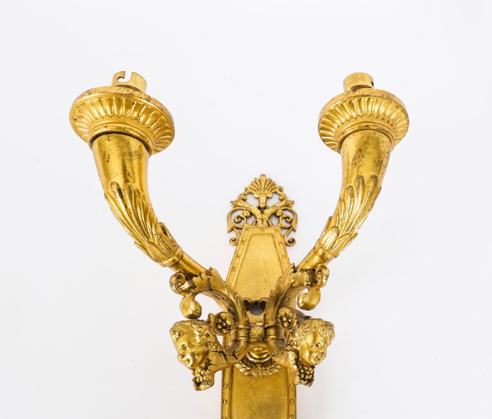 A pair of antique French Louis XIV Revival two-branch gilt bronze ormolu wall sconces decorated with cherub motifs. View VII