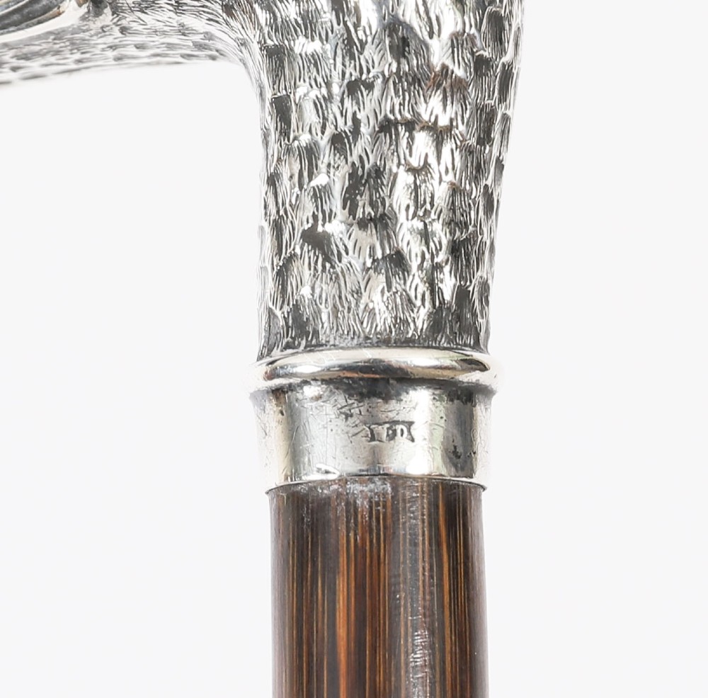 An antique walking stick featuring a dark polished wooden shaft topped with a cast silver duck head handle. View VIII