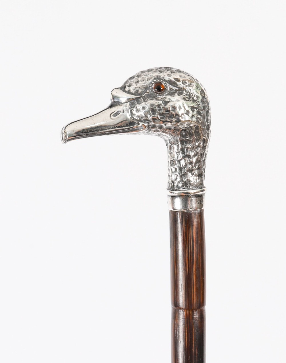 An antique walking stick featuring a dark polished wooden shaft topped with a cast silver duck head handle. View XII