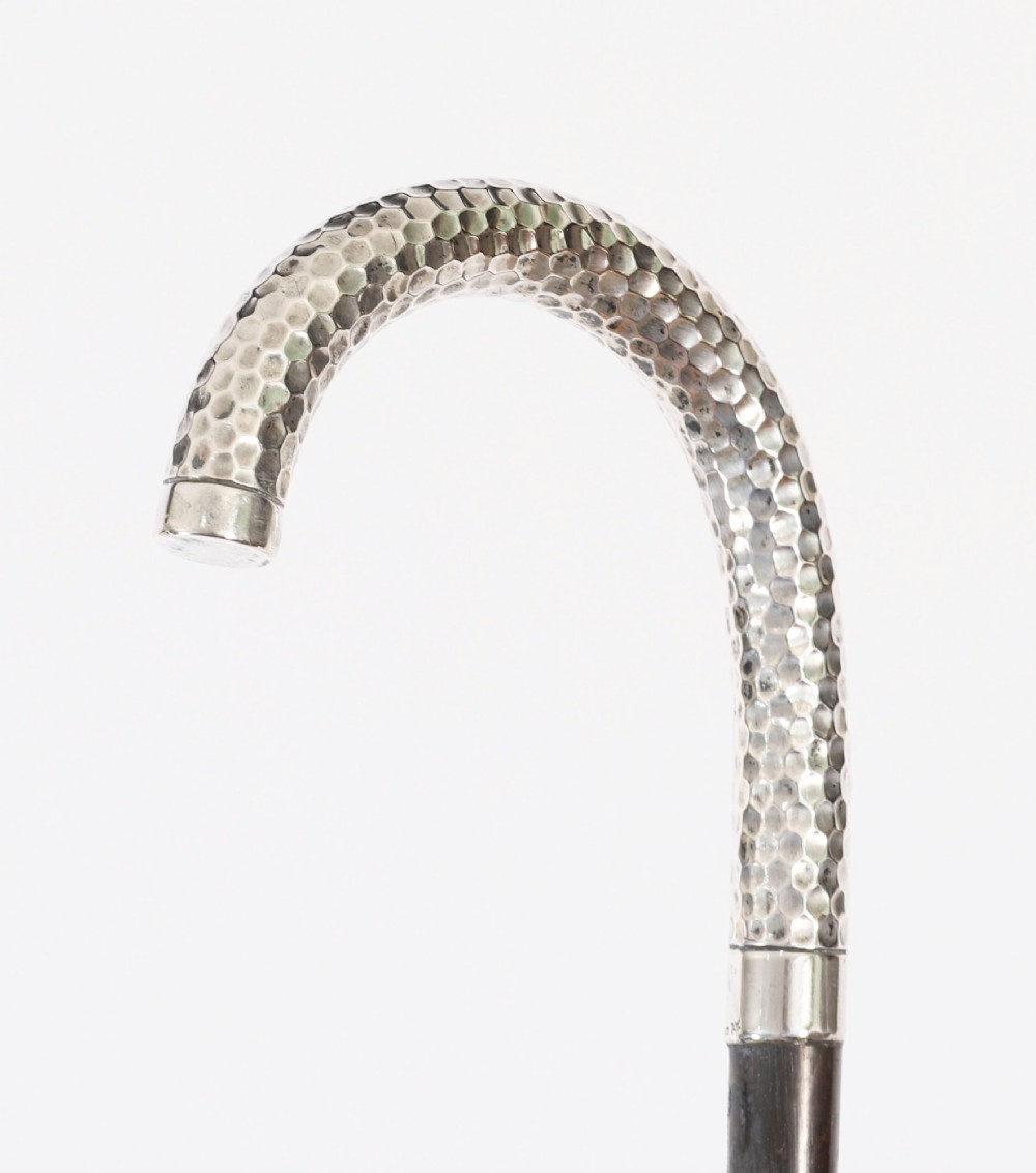 An antique French walking cane featuring a hand-hammered crook-shaped silver handle mounted on a dark wooden shaft. View III