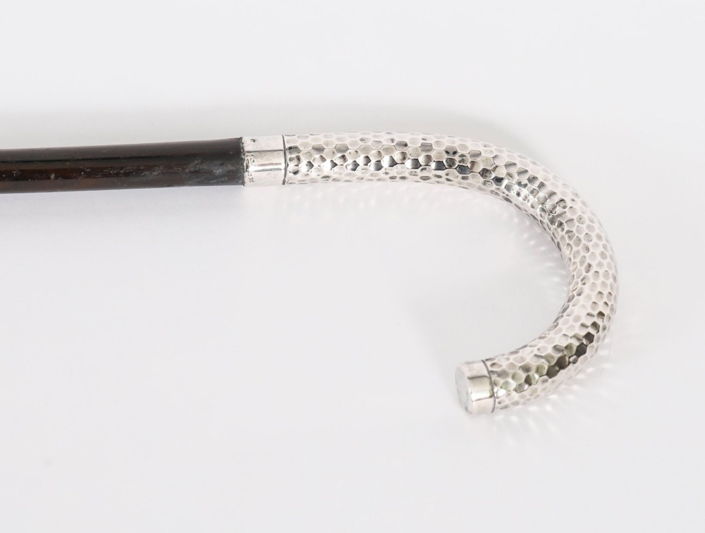 An antique French walking cane featuring a hand-hammered crook-shaped silver handle mounted on a dark wooden shaft. View IV
