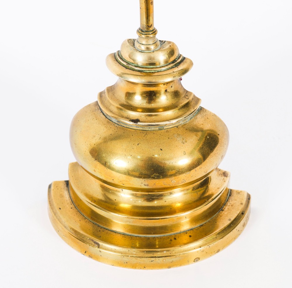 A 19th-century Victorian brass door stop featuring a tall shaft topped with a heart-shaped handle and supported by a heavy, tiered circular base. View IX