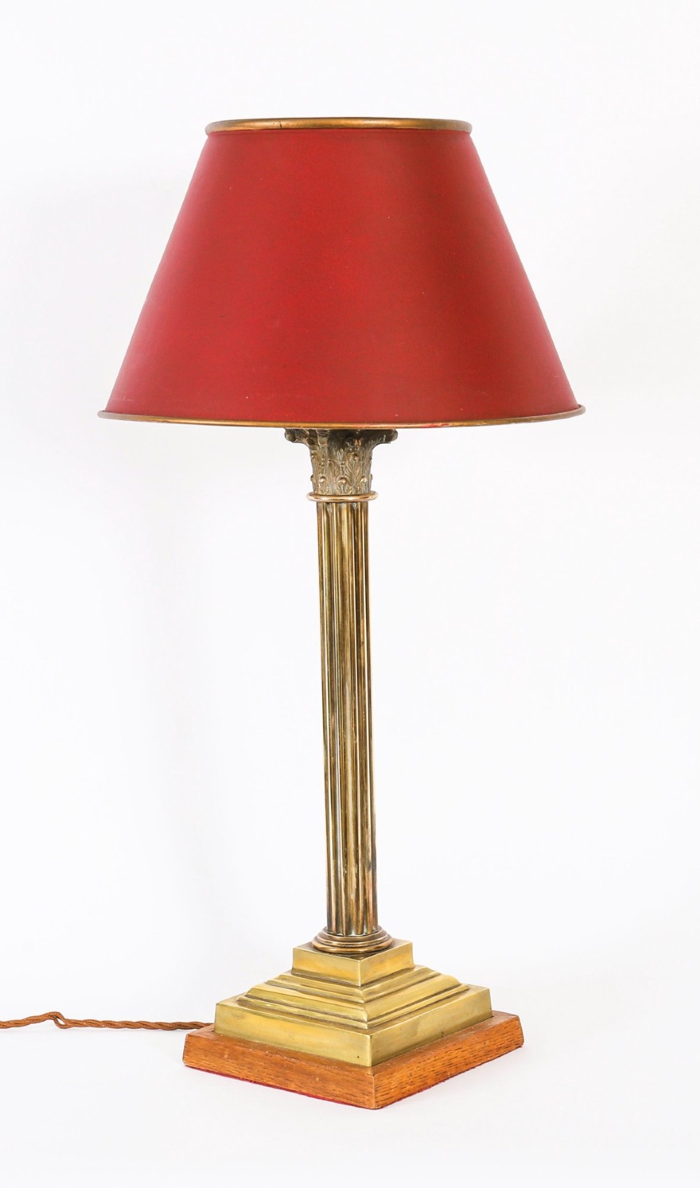 A pair of late nineteenth-century brass Corinthian column table lamps featuring fluted stems, stepped bases, wooden plinths, and conical red lampshades. View IV