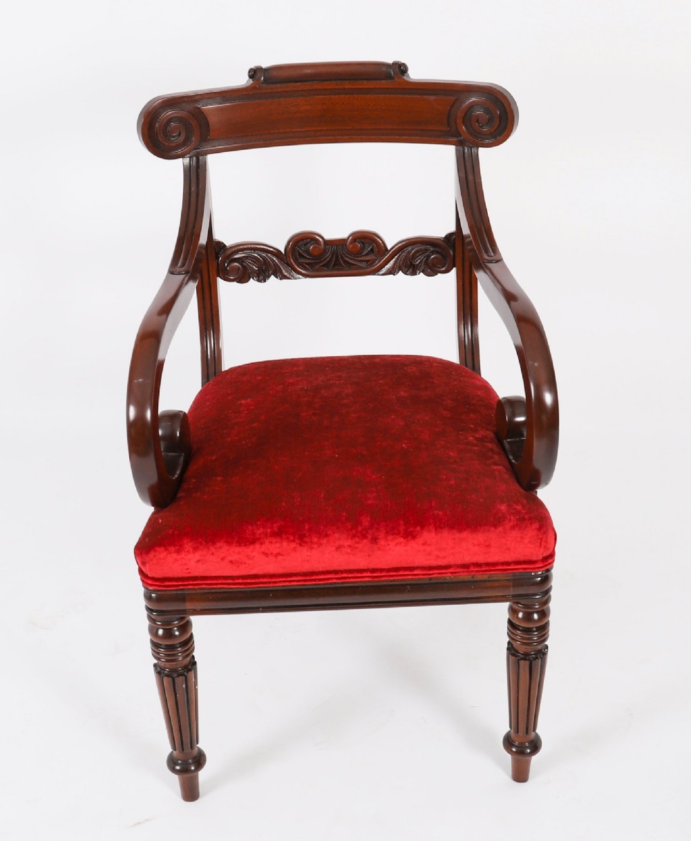 A set of ten Regency flame mahogany dining chairs with carved scroll backrails, turned fluted front legs, and red velvet seats. View III