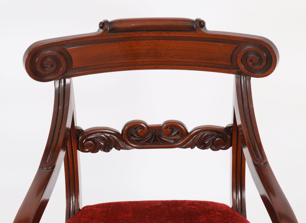 A set of ten Regency flame mahogany dining chairs with carved scroll backrails, turned fluted front legs, and red velvet seats. View IV