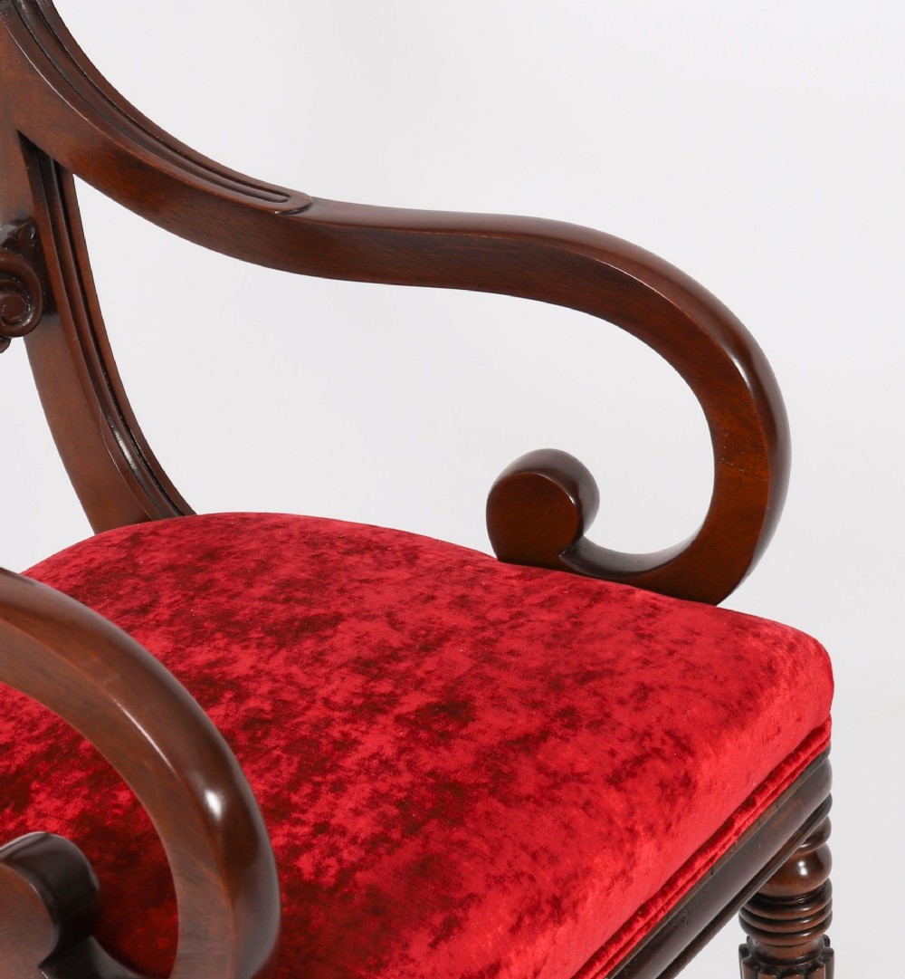 A set of ten Regency flame mahogany dining chairs with carved scroll backrails, turned fluted front legs, and red velvet seats. View V