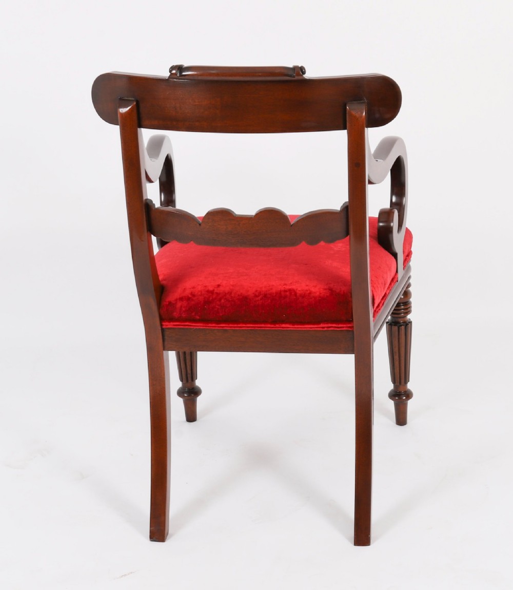 A set of ten Regency flame mahogany dining chairs with carved scroll backrails, turned fluted front legs, and red velvet seats. View VII