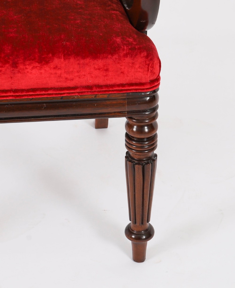A set of ten Regency flame mahogany dining chairs with carved scroll backrails, turned fluted front legs, and red velvet seats. View XIV