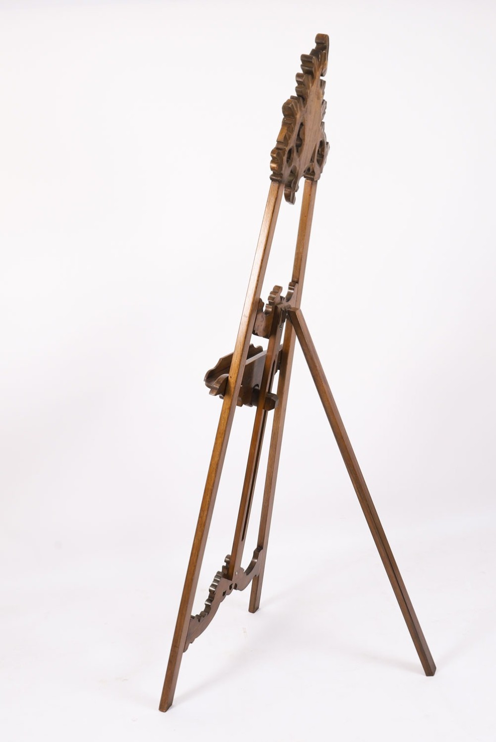 A 19th-century carved walnut artist easel featuring an ornate Rococo Revival scrollwork crest and an adjustable ledge on a tripod frame. View XIII