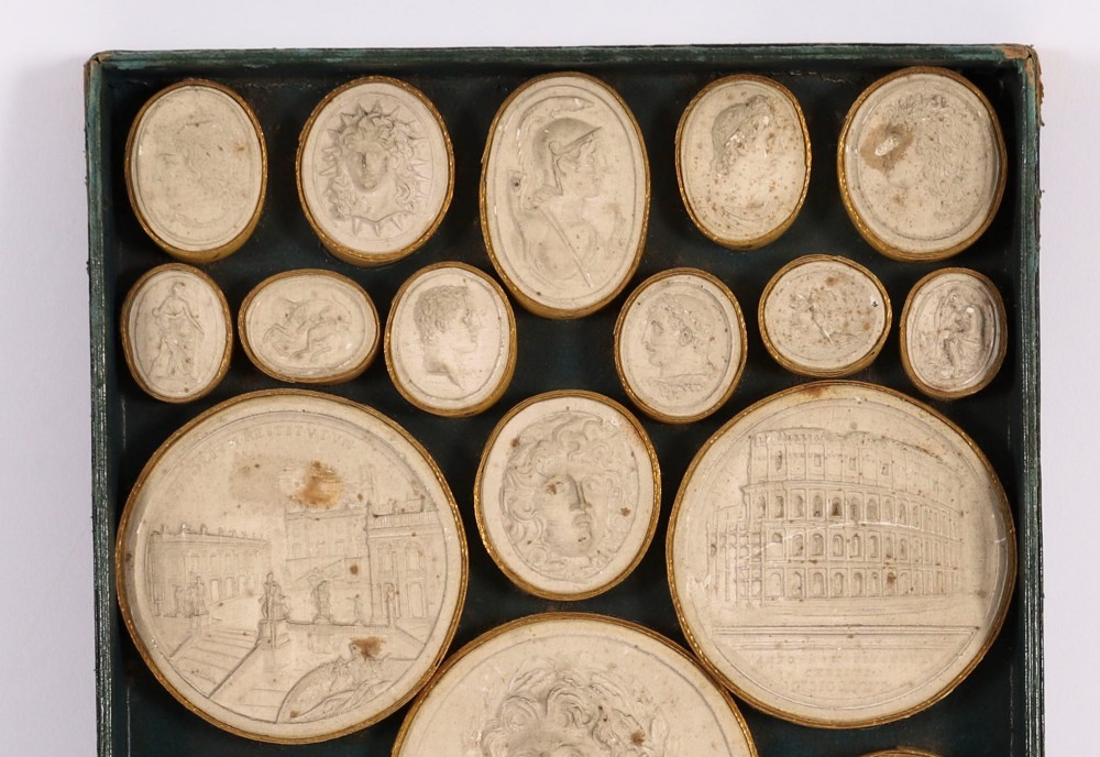 An 18th-century set of cream plaster intaglio medallions arranged in a fitted green tray beside a handwritten manuscript index lid. View IV