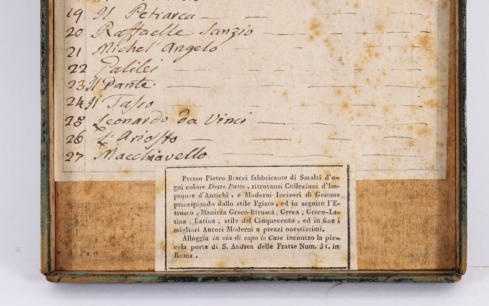 An 18th-century set of cream plaster intaglio medallions arranged in a fitted green tray beside a handwritten manuscript index lid. View VIII