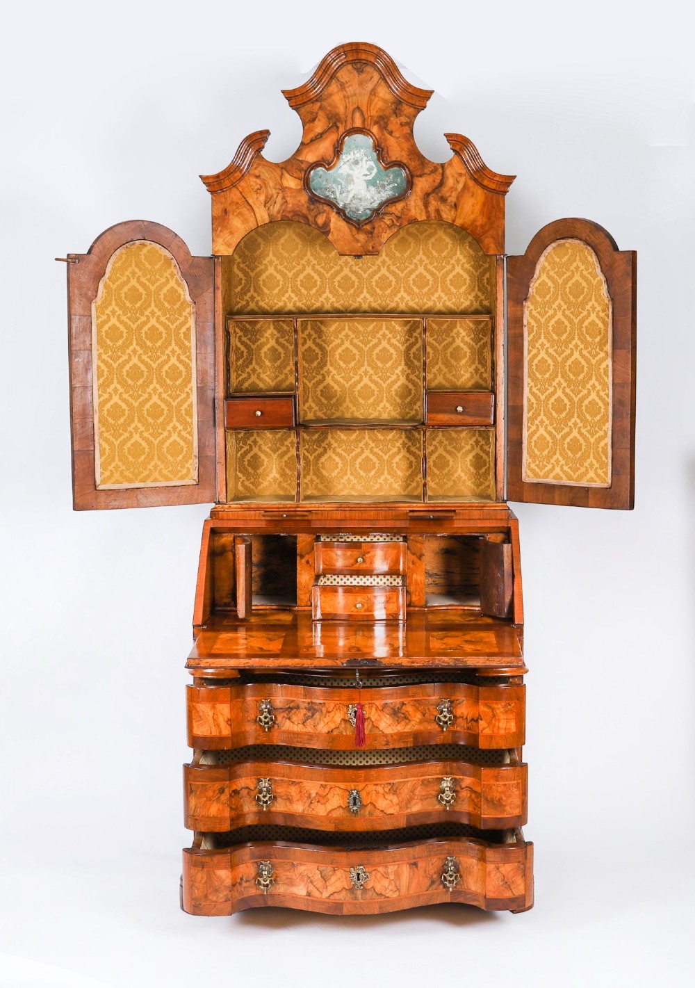 An 18th-century Venetian burr walnut bureau bookcase featuring a shaped top pediment with mirrored inset, twin mirrored cabinet doors, a slant-front writing slope, and three serpentine drawers. View III