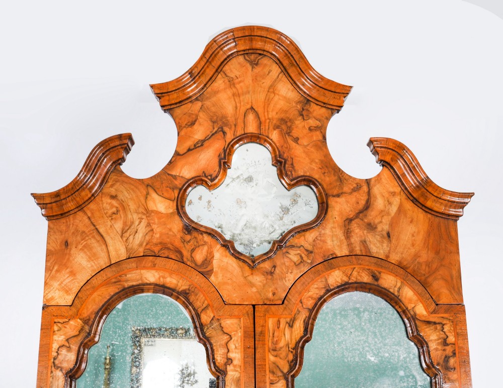 An 18th-century Venetian burr walnut bureau bookcase featuring a shaped top pediment with mirrored inset, twin mirrored cabinet doors, a slant-front writing slope, and three serpentine drawers. View IV