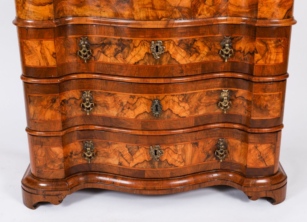 An 18th-century Venetian burr walnut bureau bookcase featuring a shaped top pediment with mirrored inset, twin mirrored cabinet doors, a slant-front writing slope, and three serpentine drawers. View VI
