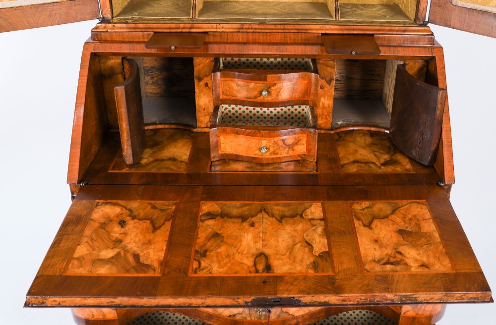 An 18th-century Venetian burr walnut bureau bookcase featuring a shaped top pediment with mirrored inset, twin mirrored cabinet doors, a slant-front writing slope, and three serpentine drawers. View IX