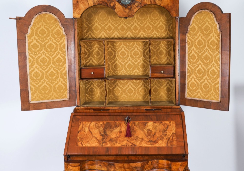 An 18th-century Venetian burr walnut bureau bookcase featuring a shaped top pediment with mirrored inset, twin mirrored cabinet doors, a slant-front writing slope, and three serpentine drawers. View XI