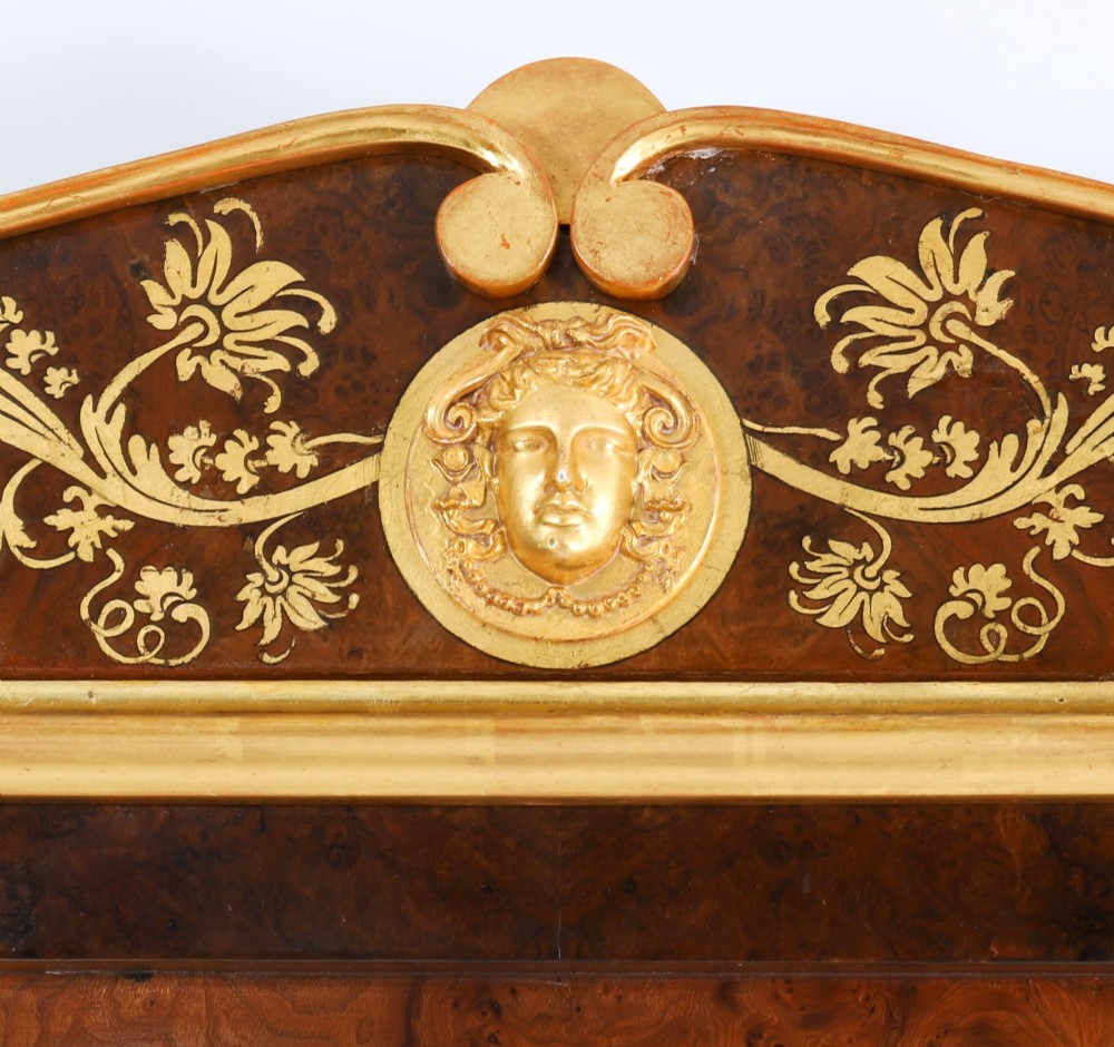 A nineteenth-century rectangular French burr walnut mirror featuring gilded fluted pilasters, classical foliate cresting with a central mask motif, and gilt rosettes. View IV