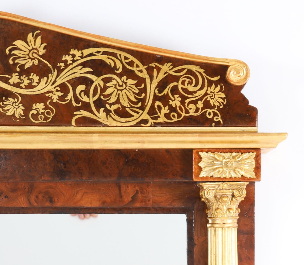A nineteenth-century rectangular French burr walnut mirror featuring gilded fluted pilasters, classical foliate cresting with a central mask motif, and gilt rosettes. View VI