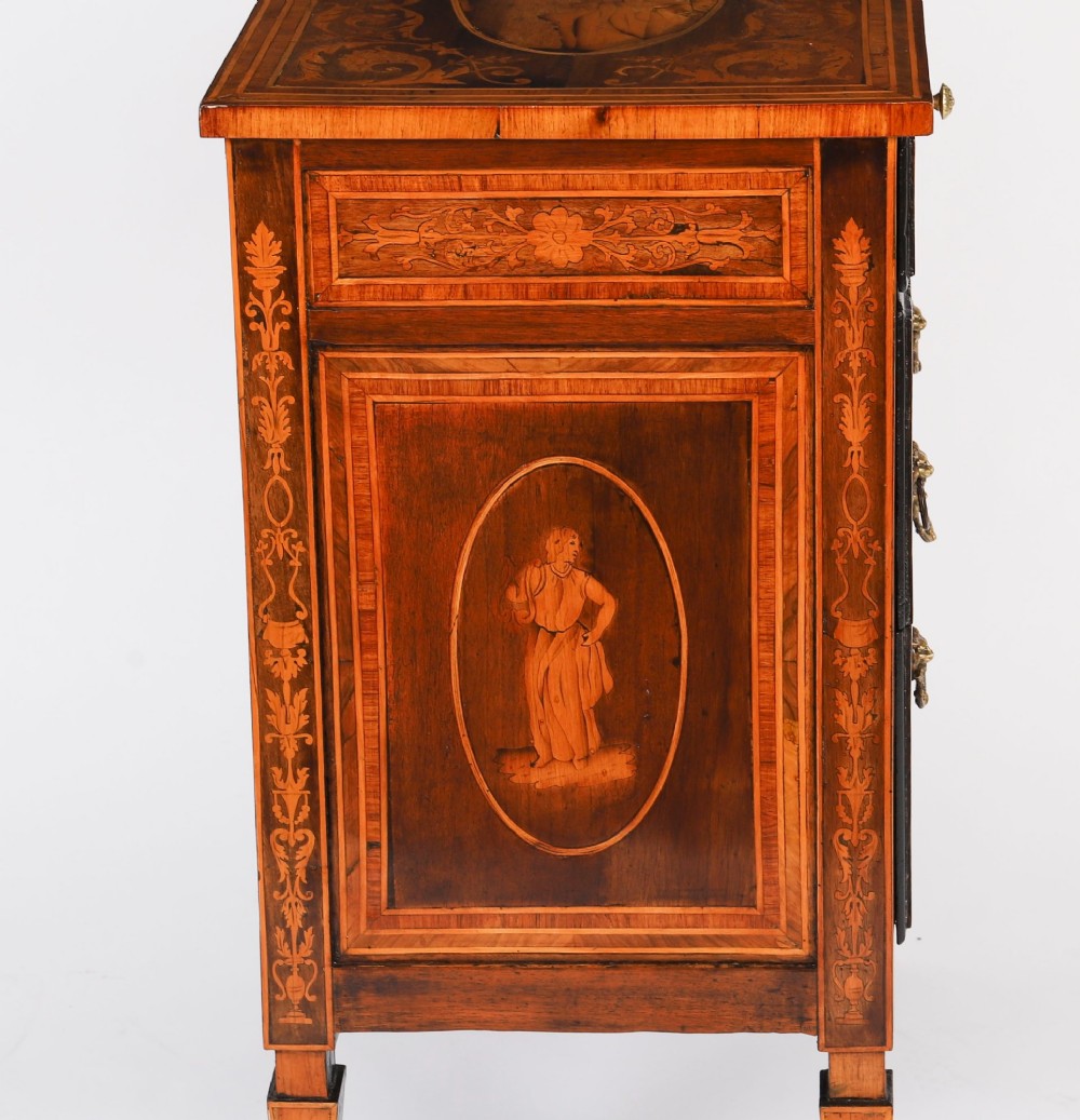 An 18th-century Italian Neoclassical walnut commodino featuring intricate foliate and pictorial marquetry inlay, three drawers with lion head ring pulls, and square tapered legs. View X
