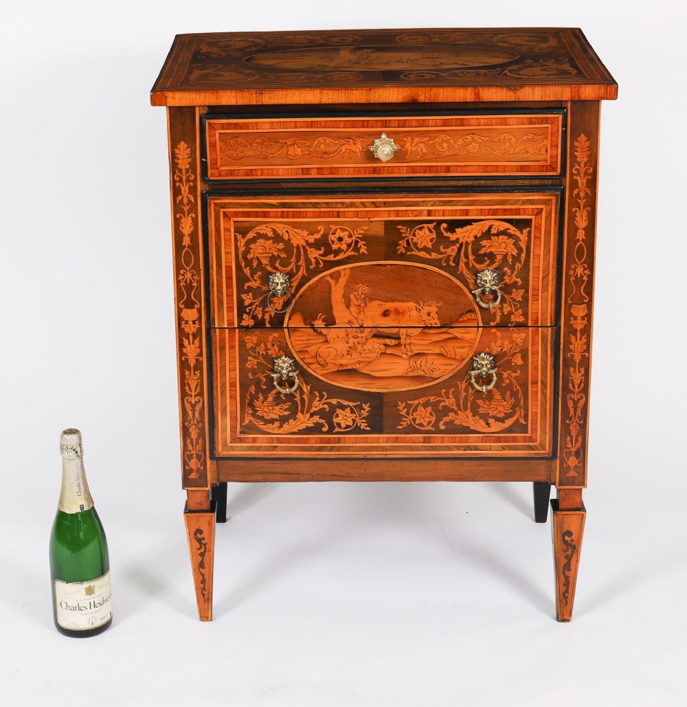 An 18th-century Italian Neoclassical walnut commodino featuring intricate foliate and pictorial marquetry inlay, three drawers with lion head ring pulls, and square tapered legs. View XV