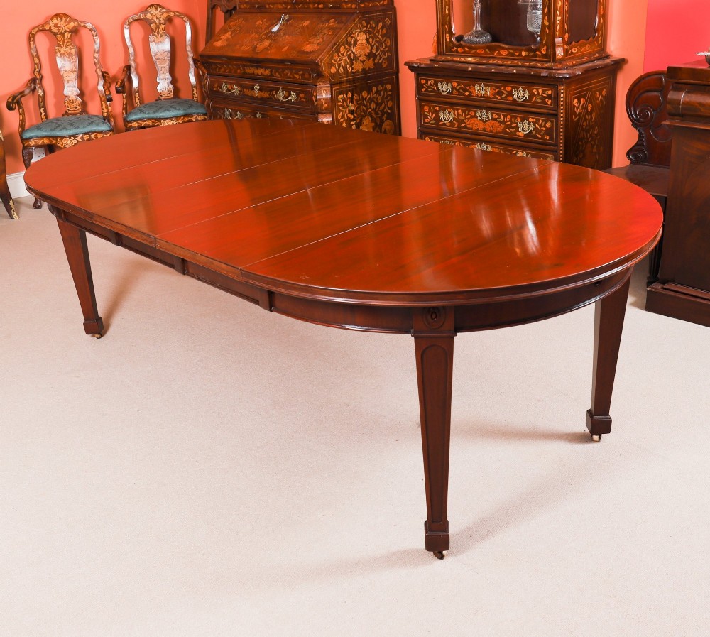 An antique Victorian oval extending dining table crafted from flame mahogany with tapered legs on brass castors.