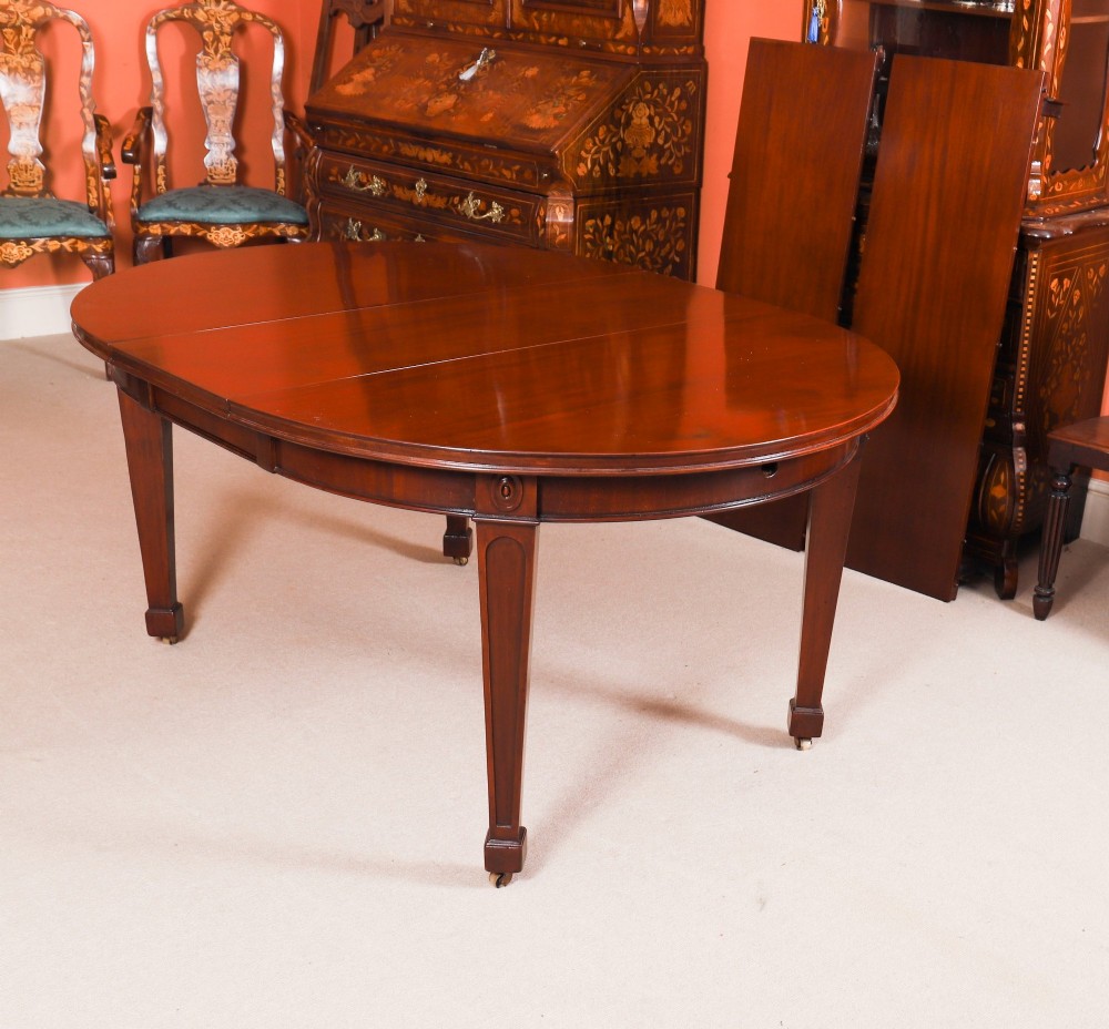 An antique Victorian oval extending dining table crafted from flame mahogany with tapered legs on brass castors. View VI
