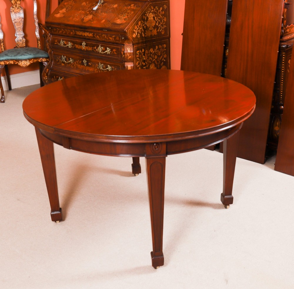 An antique Victorian oval extending dining table crafted from flame mahogany with tapered legs on brass castors. View VII