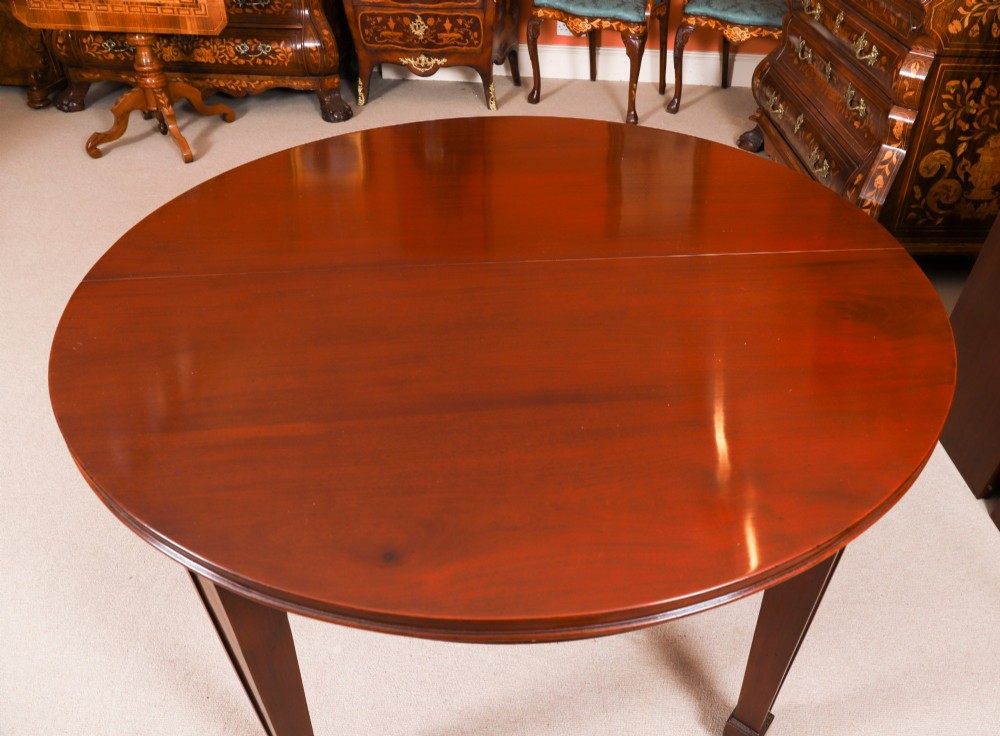 An antique Victorian oval extending dining table crafted from flame mahogany with tapered legs on brass castors. View VIII
